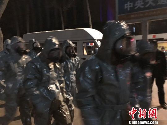 十几名身着防护服的人员头戴面具进入事发地。　胡健 摄